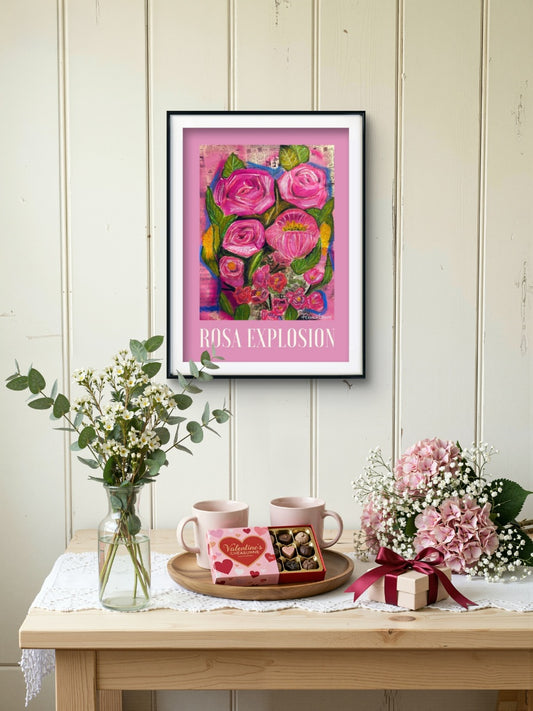 ROSA EXPLOSION 30x40 cm konstposter med rosa blomstermotiv i svart ram på en vit trävägg.